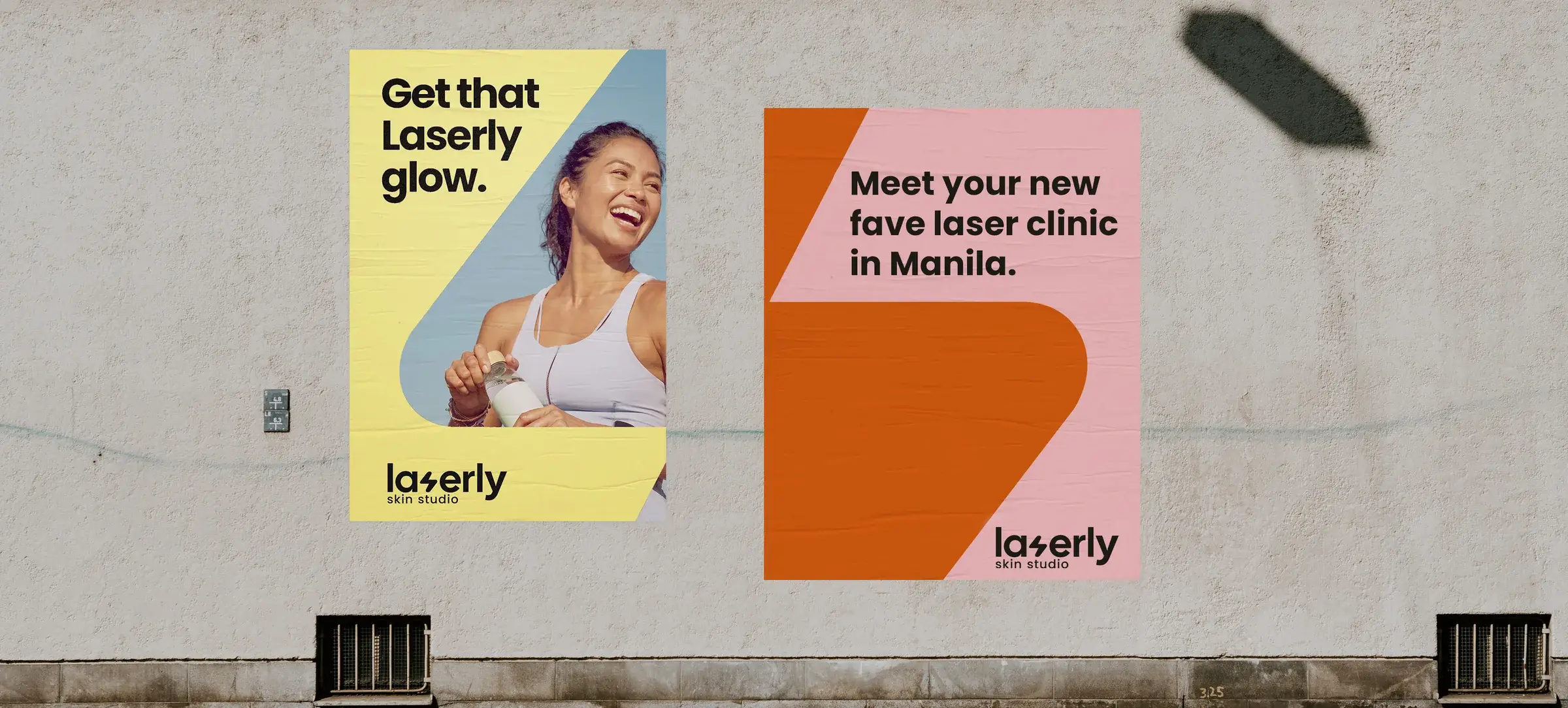 Two Laserly posters pasted on a concrete wall in the street
